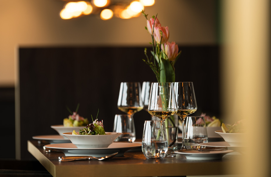 Gedeckter Tisch mit Salat und Wein im Restaurant Weidblick | TARGET WORLD